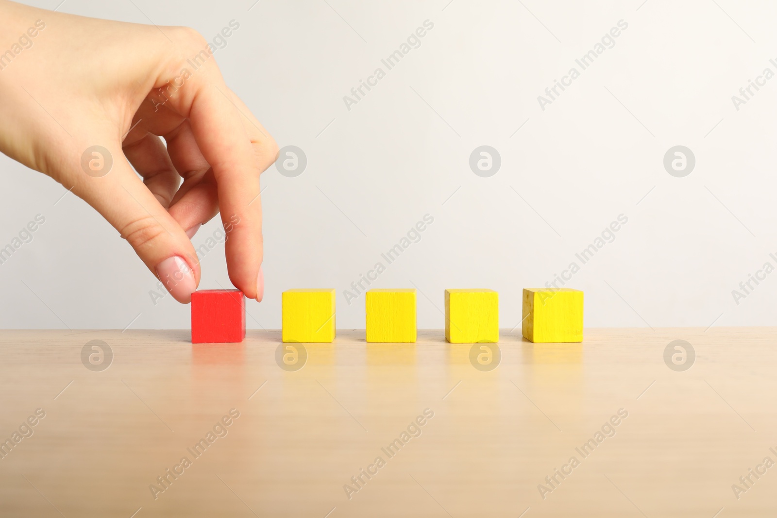 Photo of Woman with colorful cubes at table, closeup