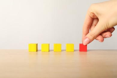 Photo of Woman with colorful cubes at table, closeup