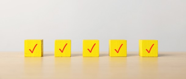 Photo of Yellow cubes with check marks on table