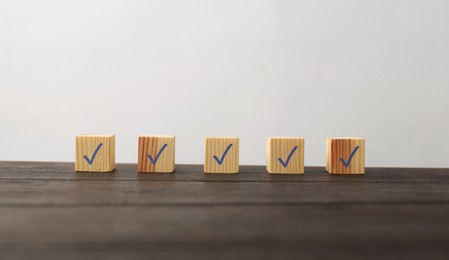 Photo of Wooden cubes with check marks on table