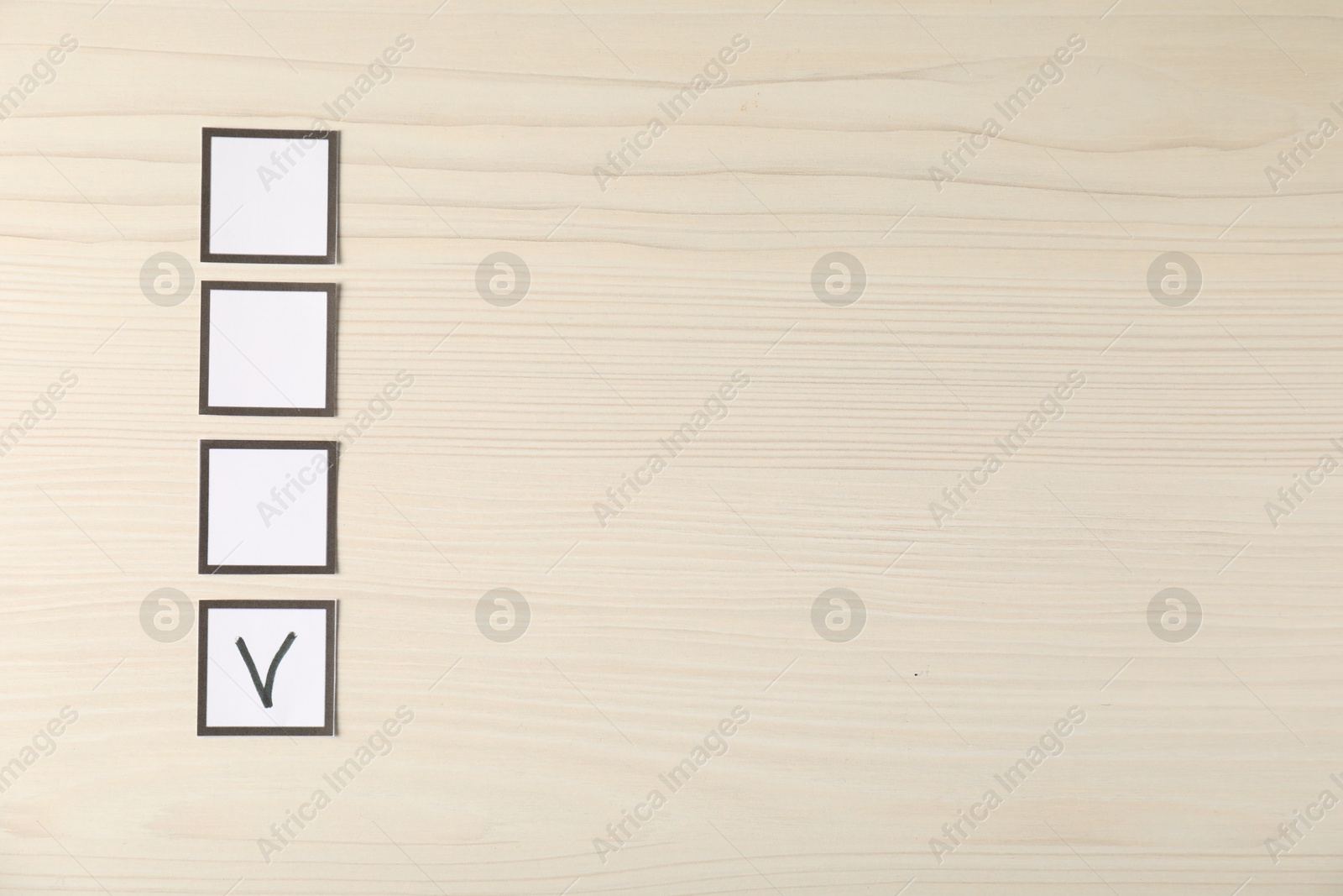 Photo of One checkbox with tick mark among others on wooden table, flat lay. Space for text