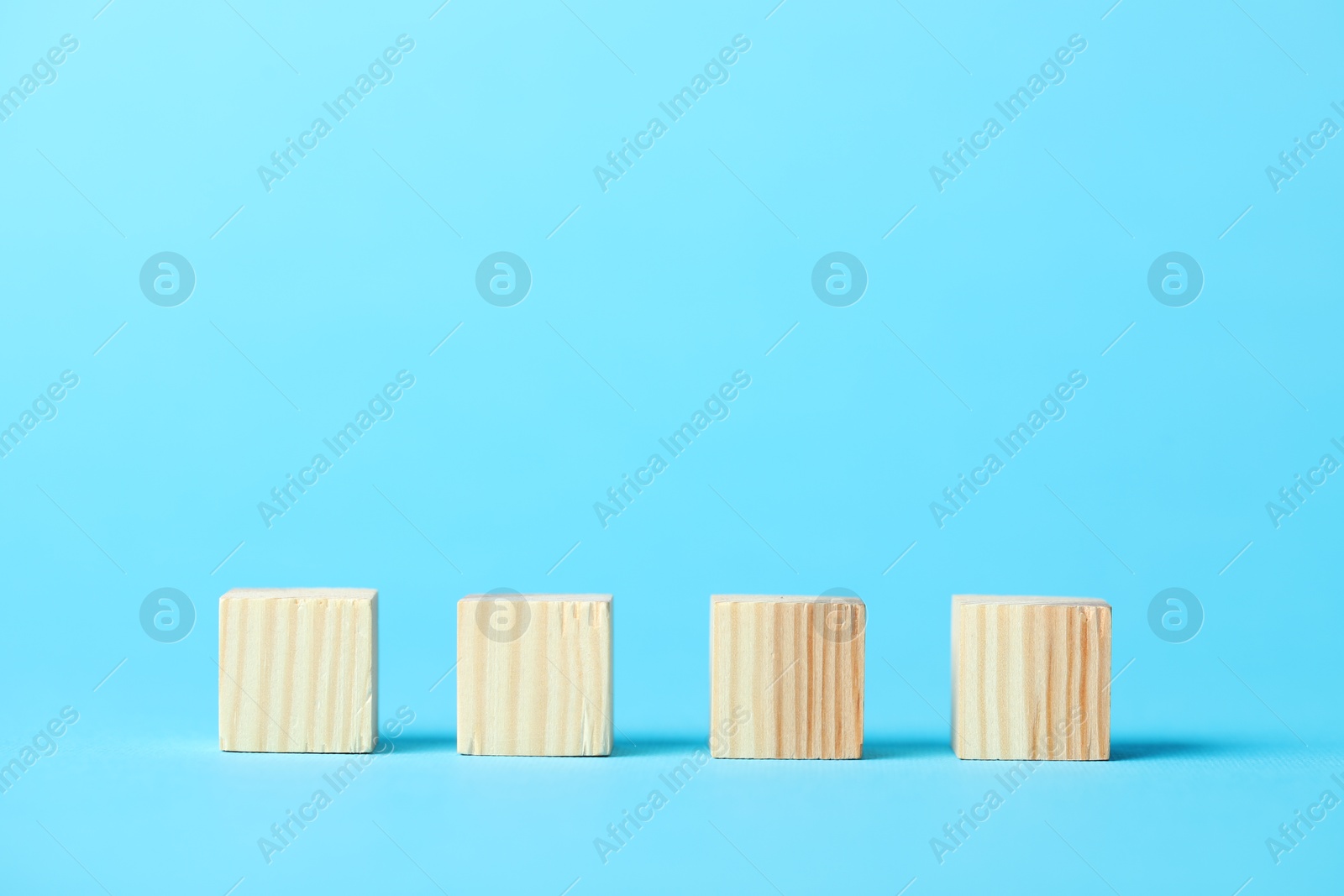 Photo of Many wooden cubes on light blue background