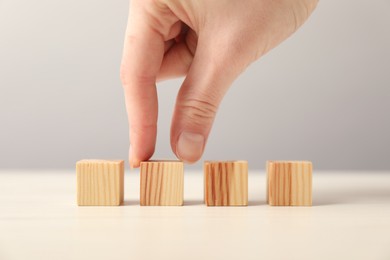 Photo of Woman with wooden cubes at table, closeup