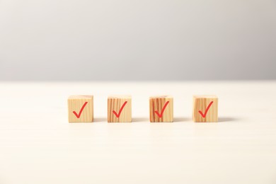 Photo of Wooden cubes with check marks on light table