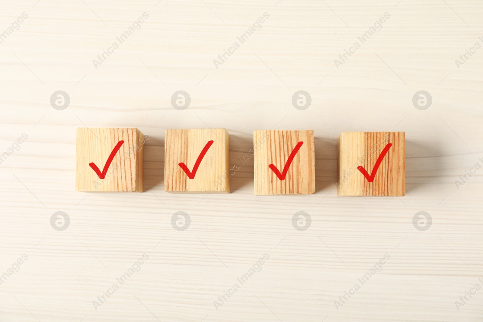 Photo of Wooden cubes with check marks on table, flat lay