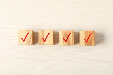 Photo of Wooden cubes with check marks on table, flat lay