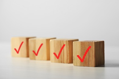 Photo of Wooden cubes with check marks on light table, closeup