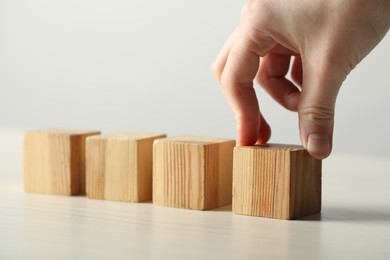 Photo of Woman with wooden cubes at light table, closeup