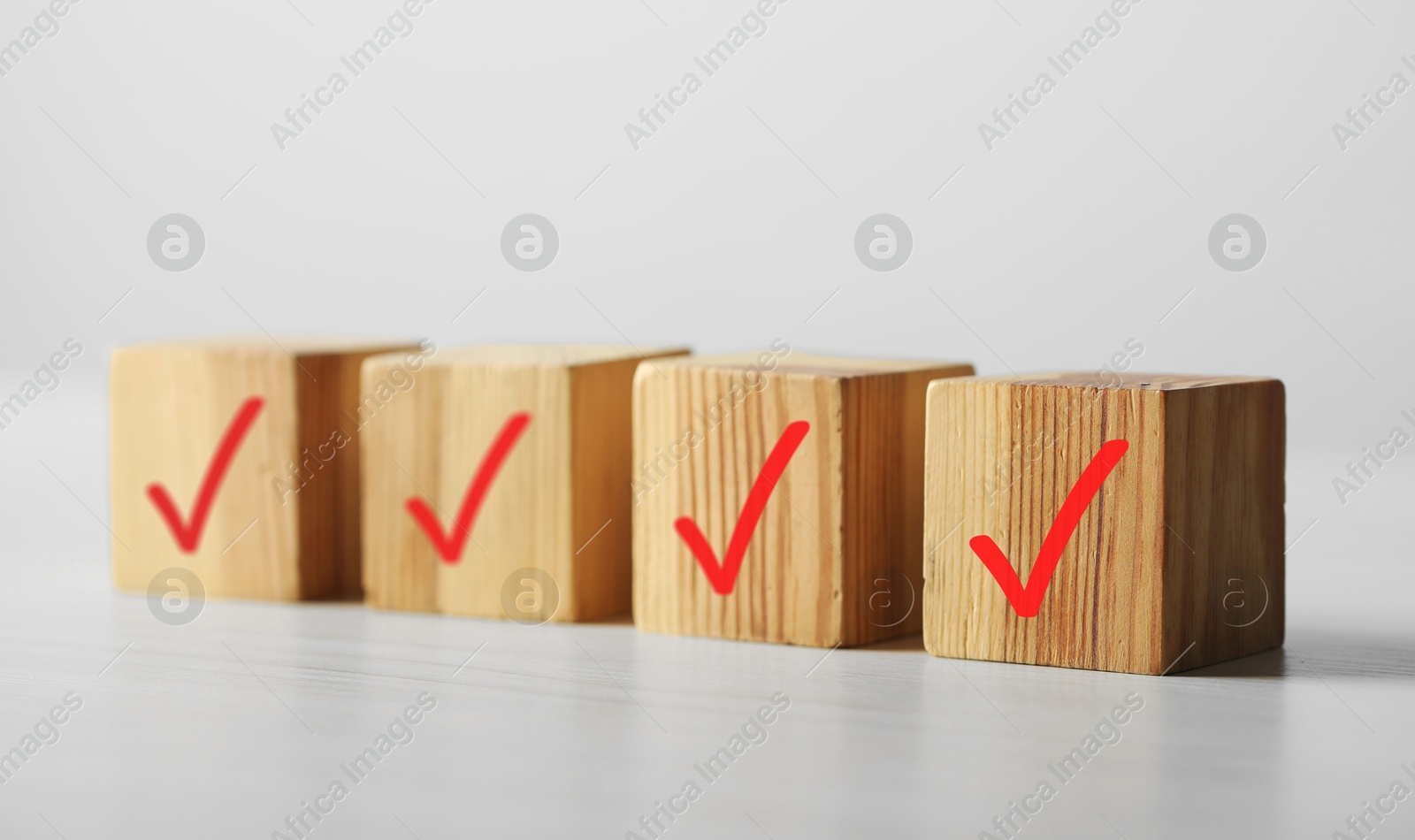 Photo of Wooden cubes with check marks on light table, closeup