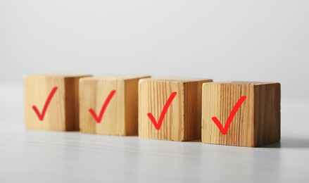 Photo of Wooden cubes with check marks on light table, closeup