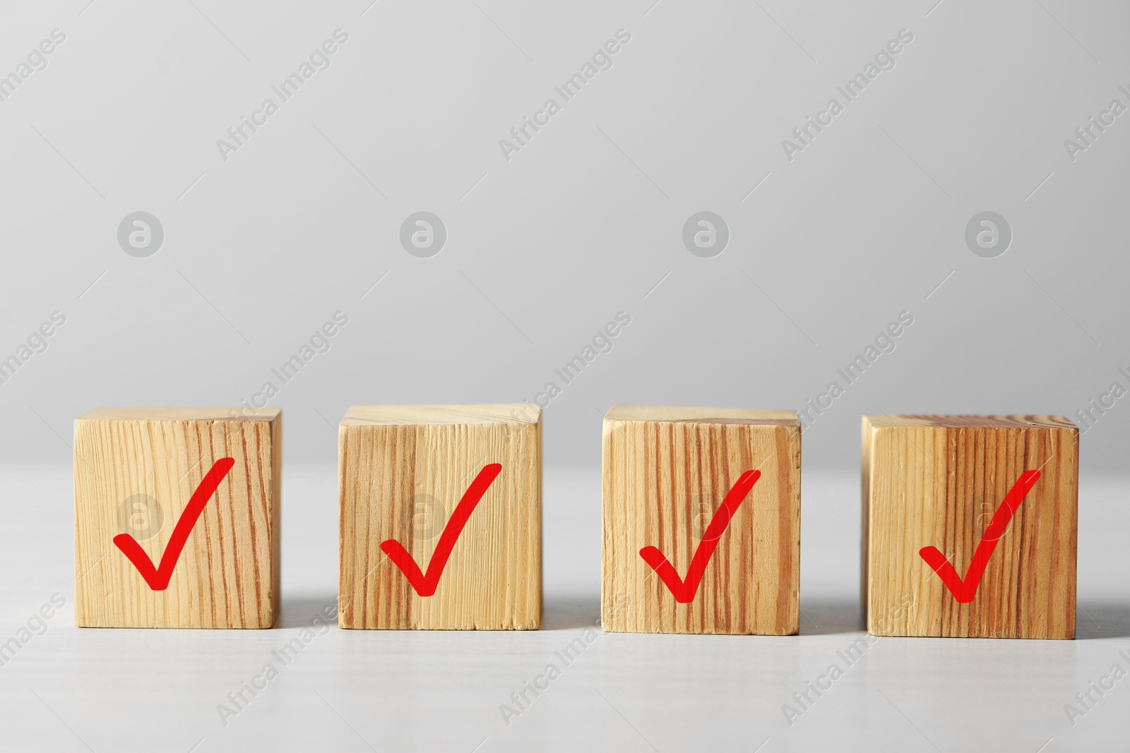 Photo of Wooden cubes with check marks on light table