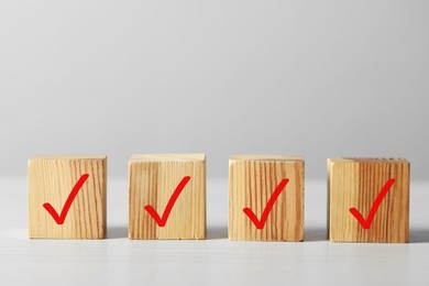 Photo of Wooden cubes with check marks on light table