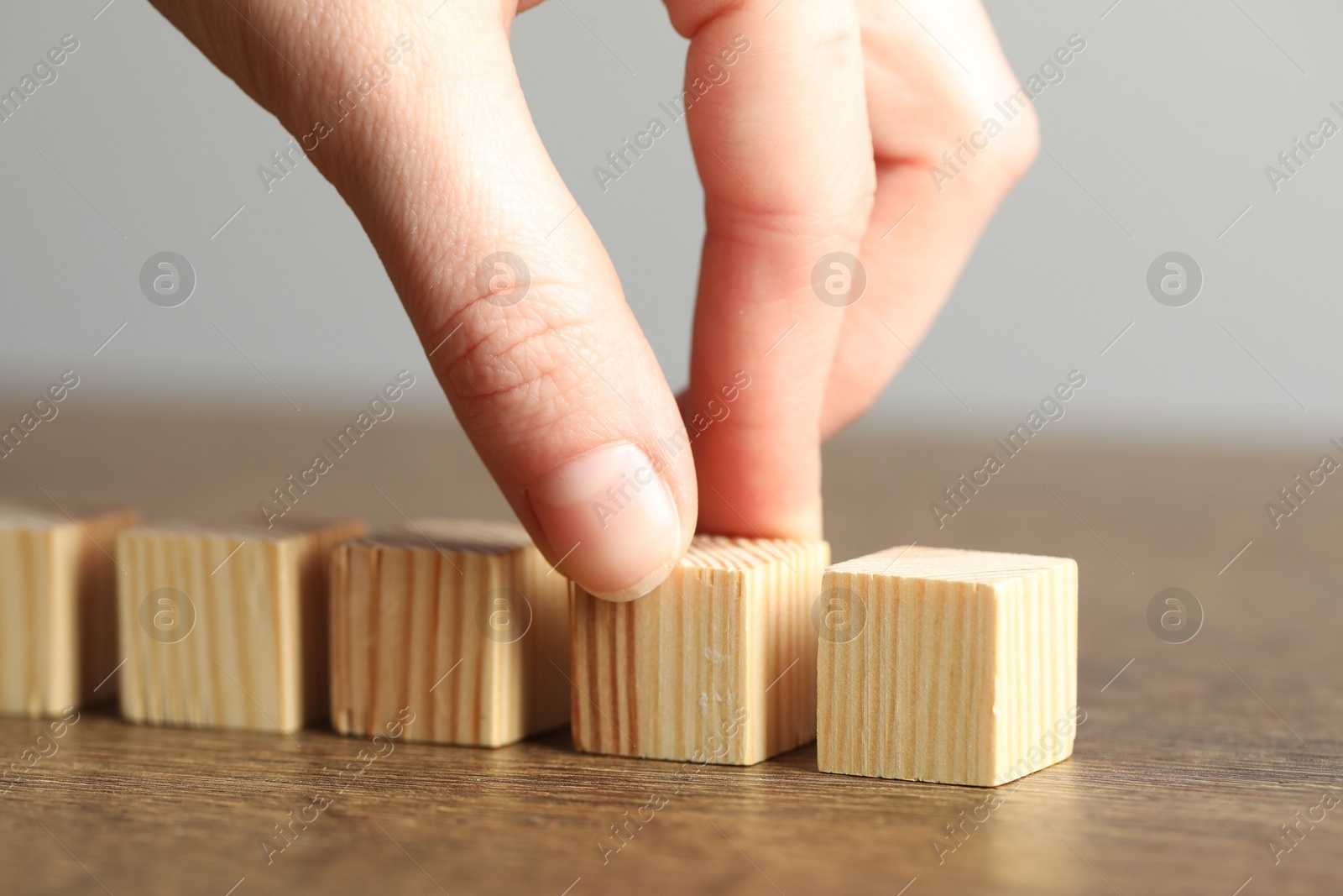 Photo of Woman with wooden cubes at table, closeup