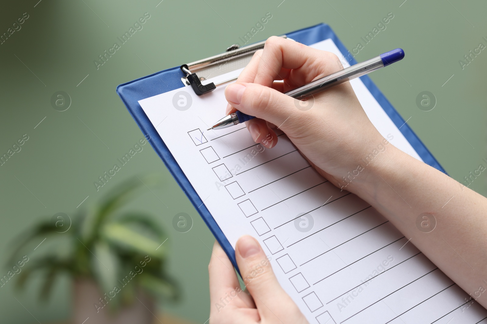 Photo of Woman checking box of paper form indoors, closeup