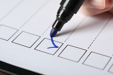 Photo of Woman checking box of paper form, closeup