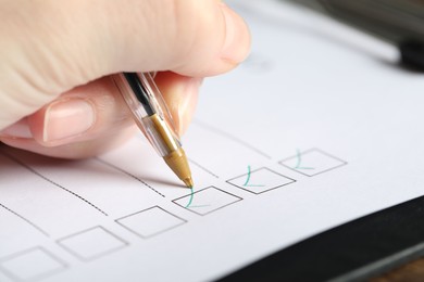 Photo of Woman checking box of paper form, closeup