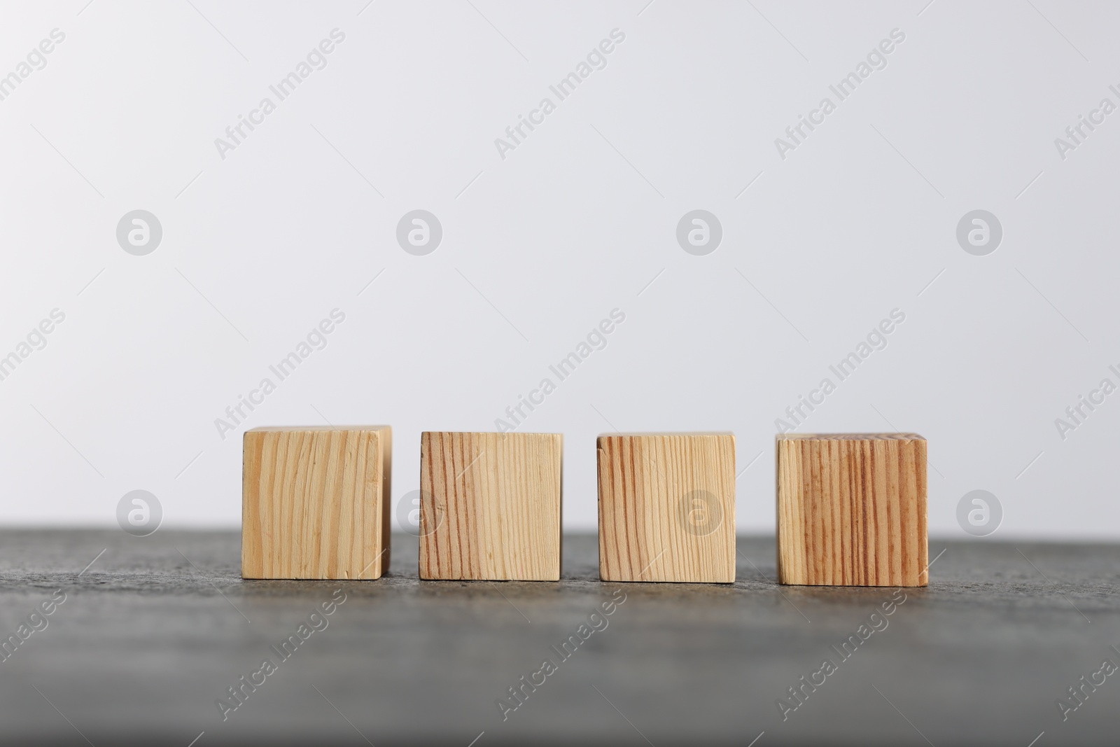 Photo of Many wooden cubes on grey table, space for text