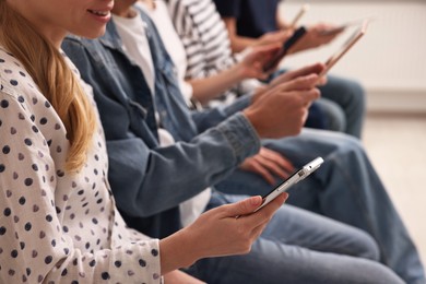 Photo of Group of people using different gadgets indoors, closeup. Modern technology