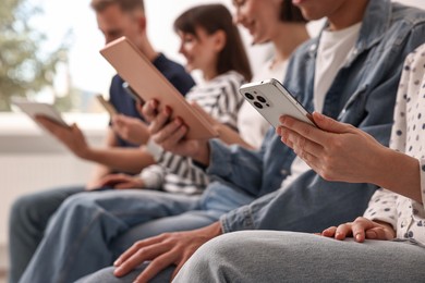 Photo of Group of people using different gadgets indoors, closeup. Modern technology