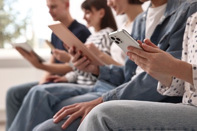 Photo of Group of people using different gadgets indoors, closeup. Modern technology