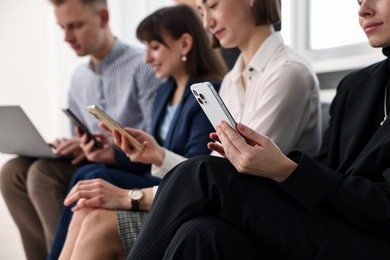 Photo of Group of people using different gadgets indoors, selective focus. Modern technology