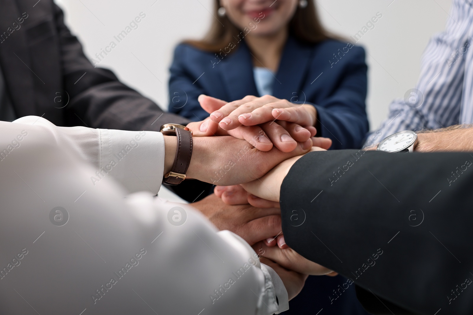 Photo of Teamwork. Group of people joining hands together indoors, closeup