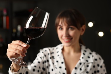 Photo of Professional sommelier analyzing quality of red wine indoors, selective focus