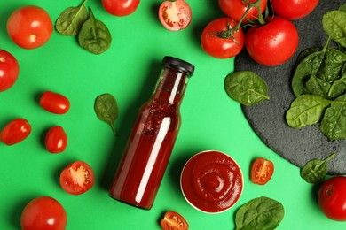 Photo of Ketchup, tomatoes and spinach on green background, flat lay