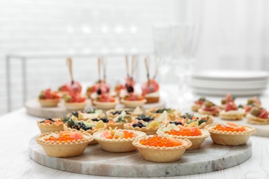 Photo of Many different tasty canapes on white wooden table, closeup