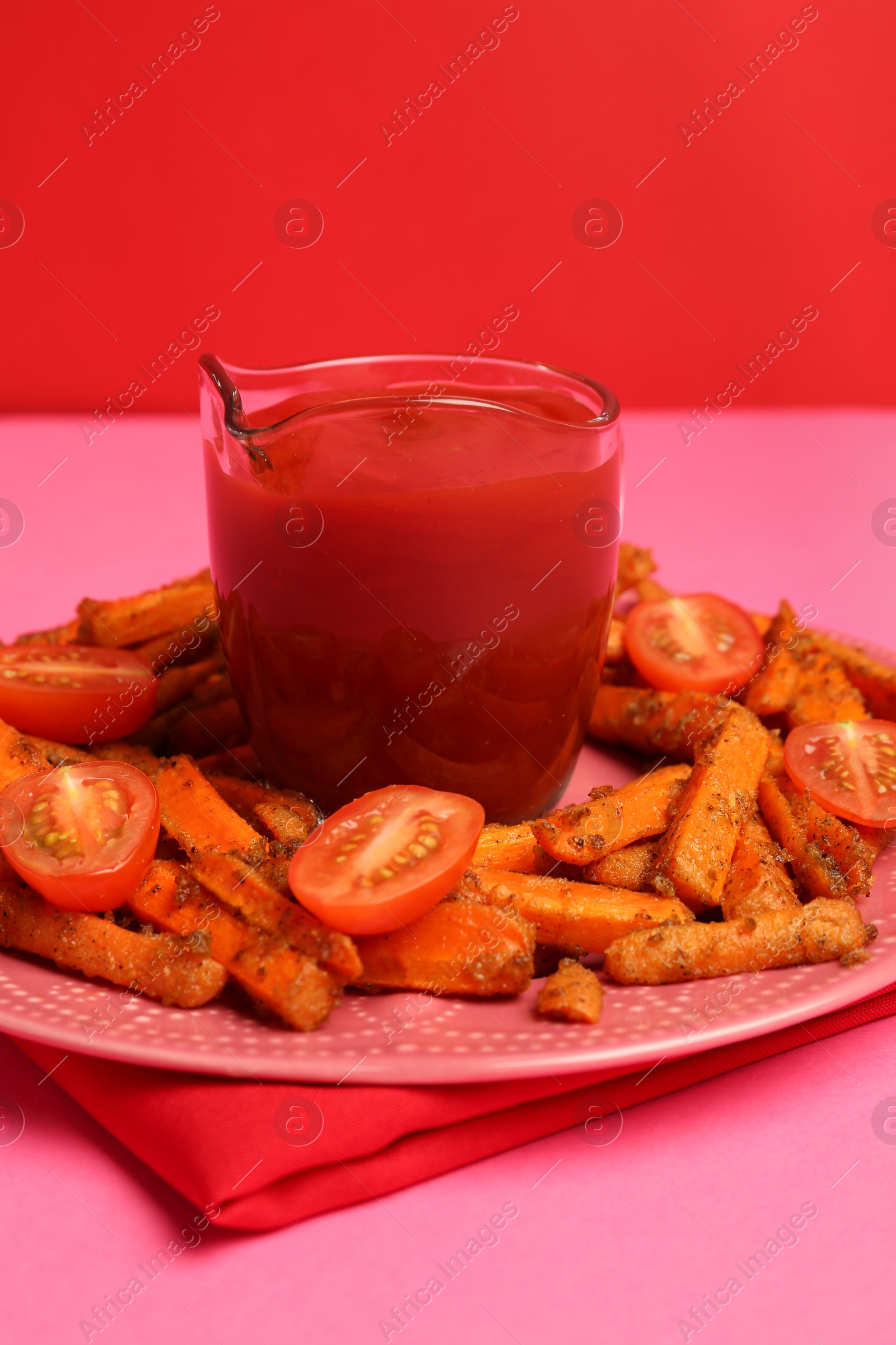 Photo of Tasty ketchup, tomatoes and fried carrots on color background, closeup