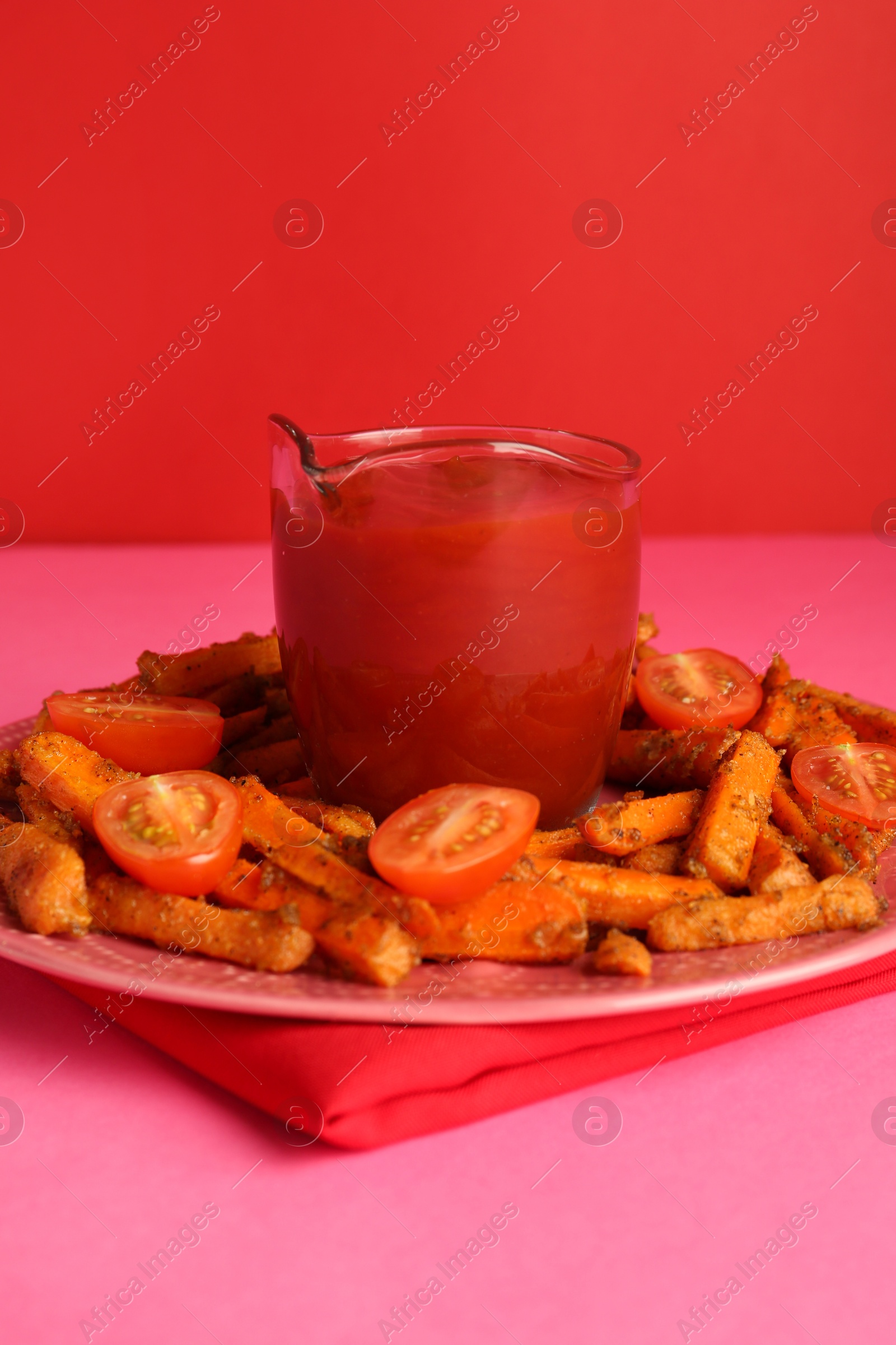 Photo of Tasty ketchup, tomatoes and fried carrots on color background, closeup