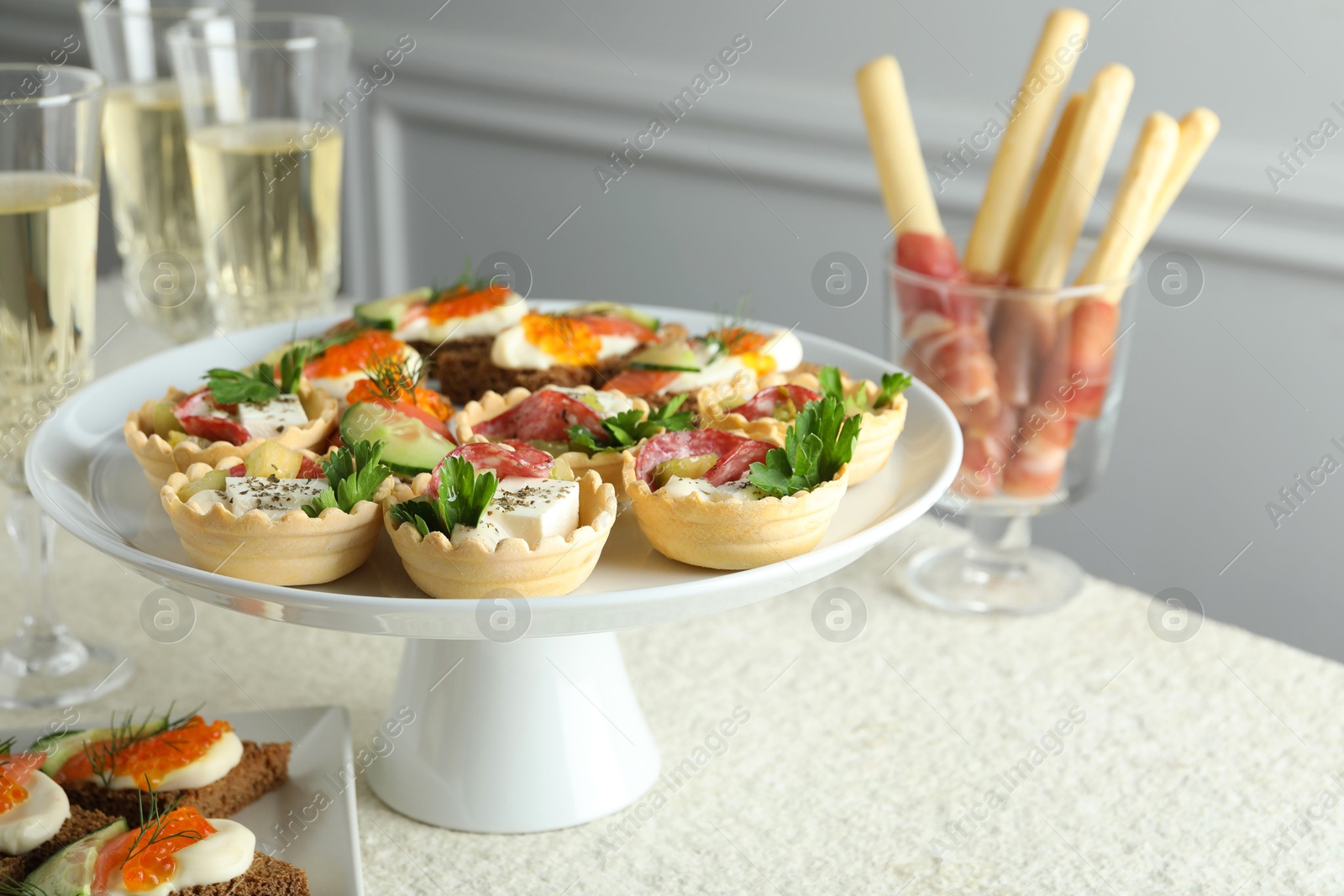 Photo of Many different tasty canapes and wine on white table