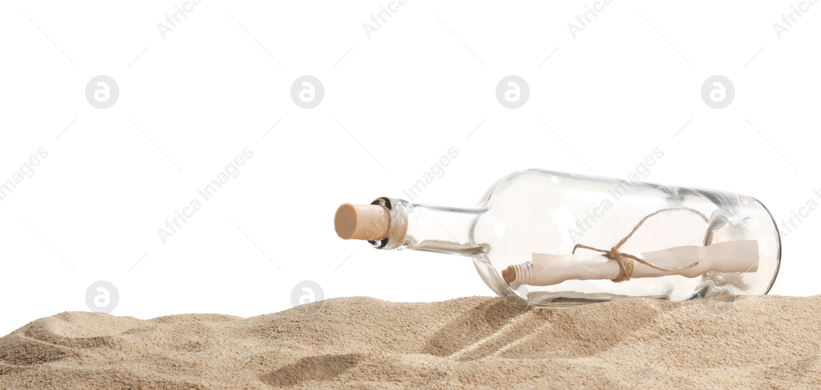 Photo of Rolled letter in corked glass bottle on sand against white background