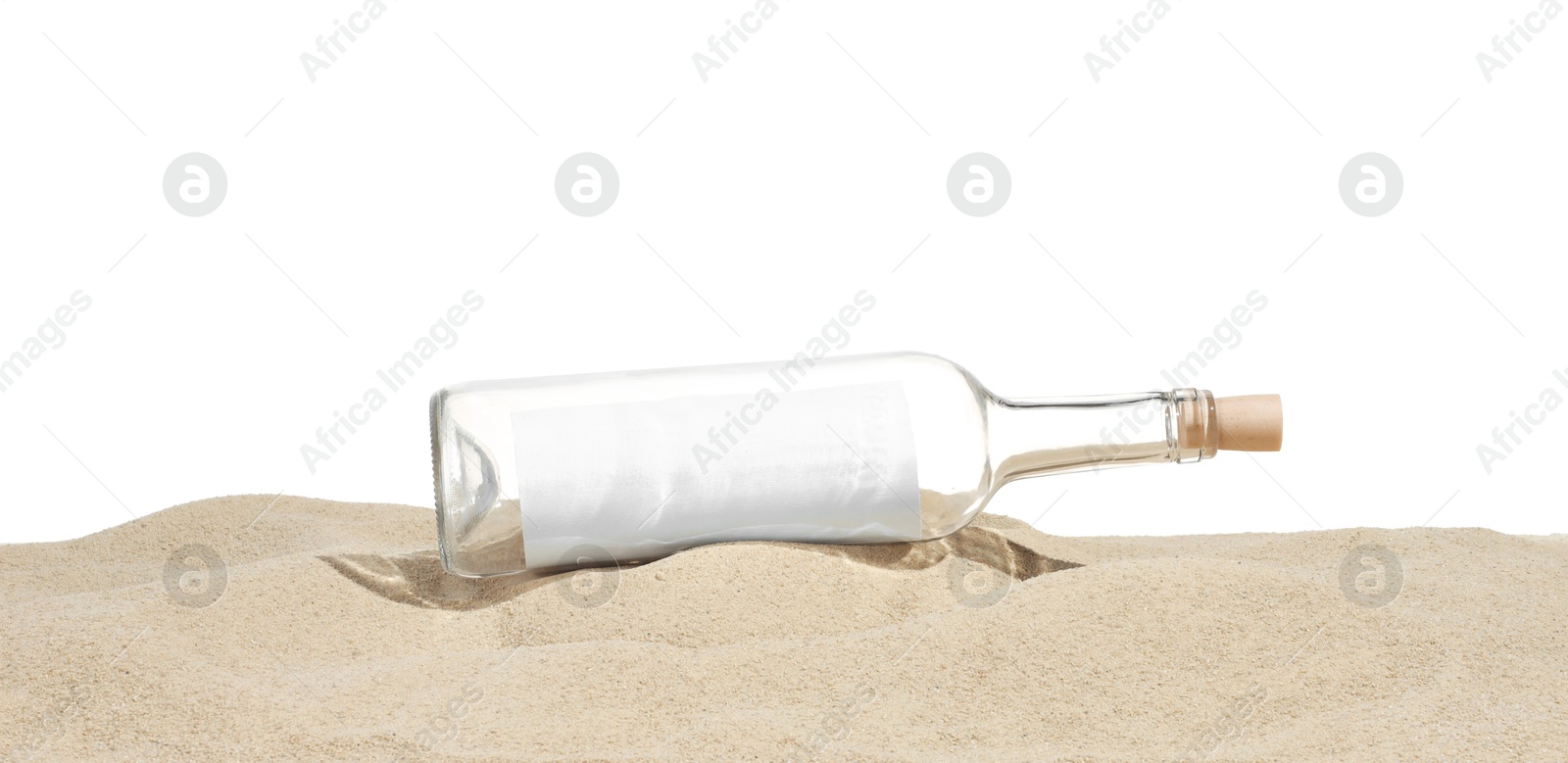 Photo of Rolled letter in corked glass bottle on sand against white background