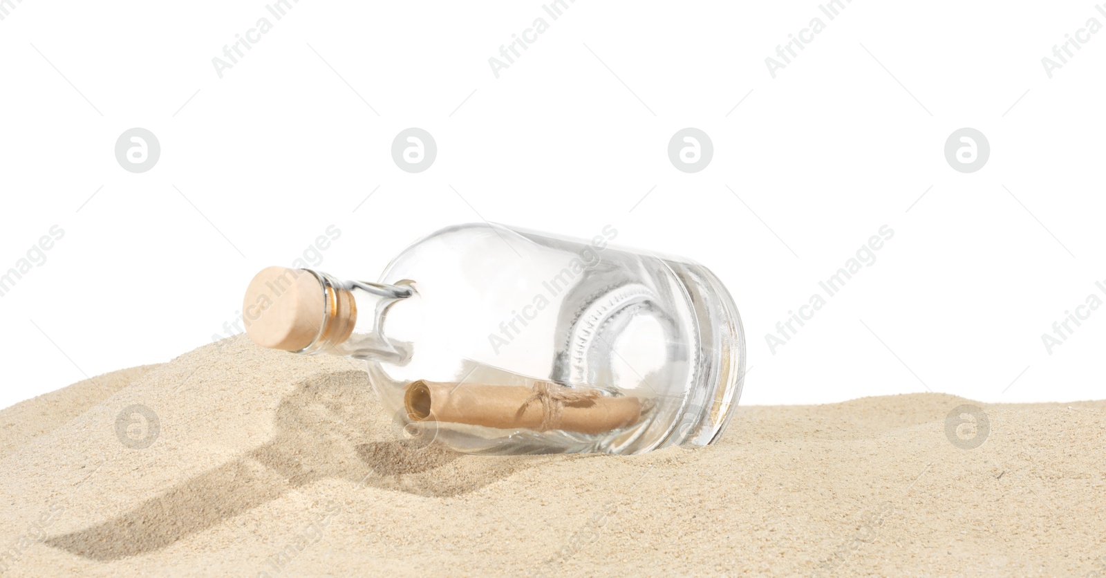 Photo of Rolled letter in corked glass bottle on sand against white background