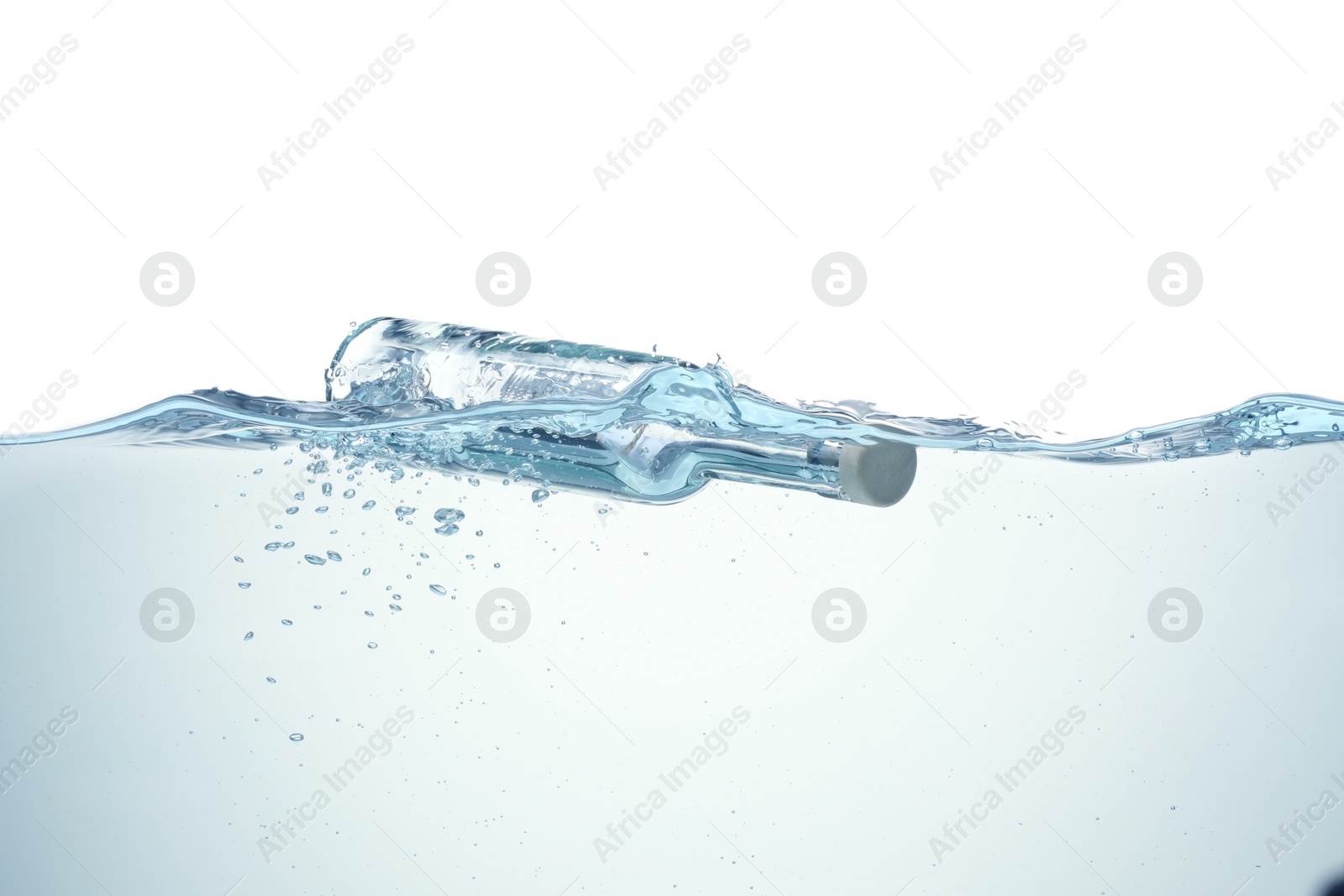 Photo of Corked glass bottle with rolled letter in water on white background