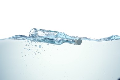 Photo of Corked glass bottle with rolled letter in water on white background