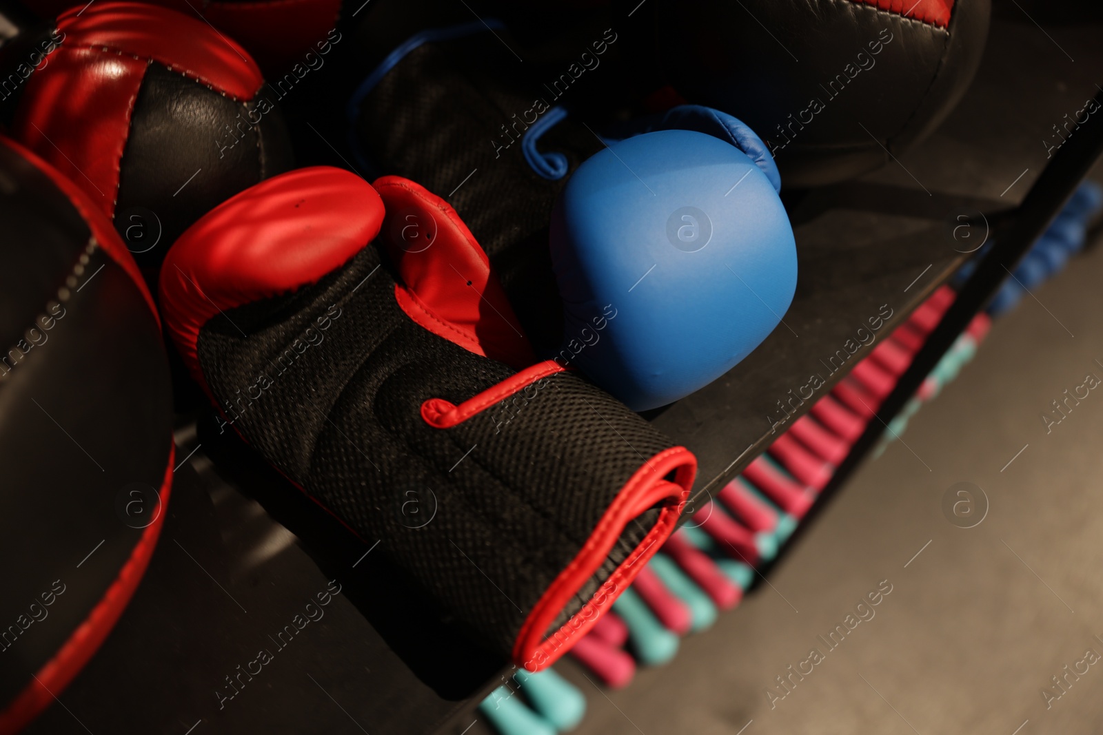 Photo of Different sport equipment on shelfs in training center, closeup