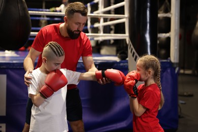 Photo of Boxing coach training children in sport center