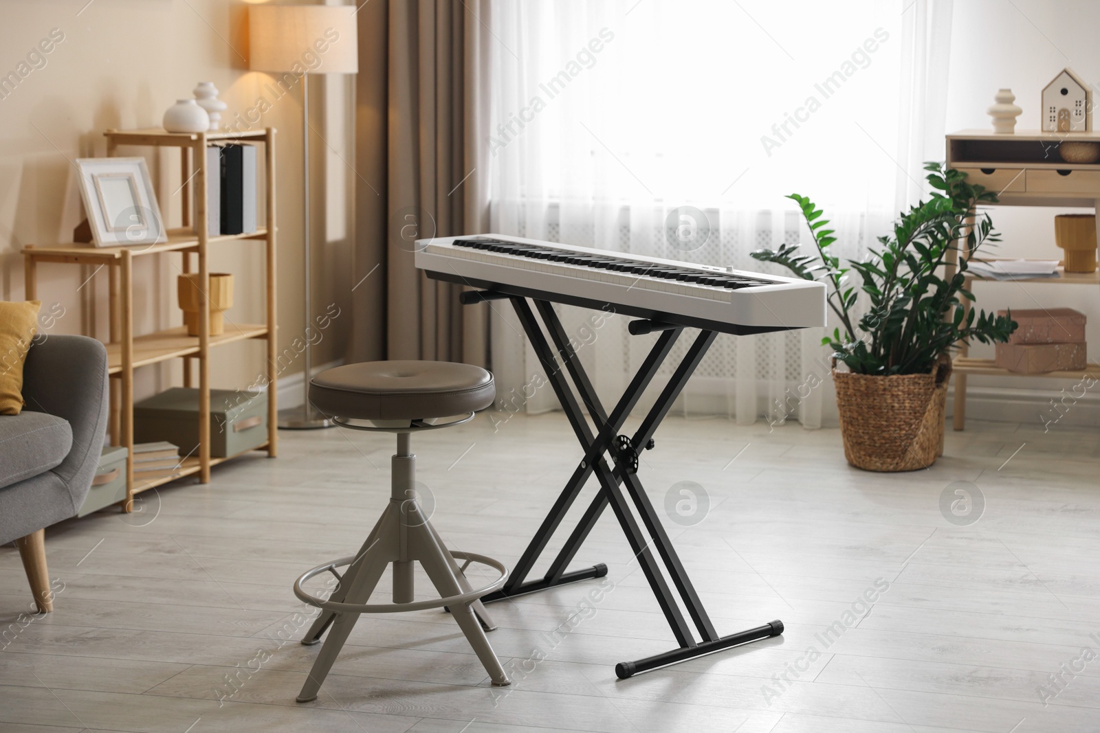 Photo of Synthesizer and stool indoors. Electronic musical instrument