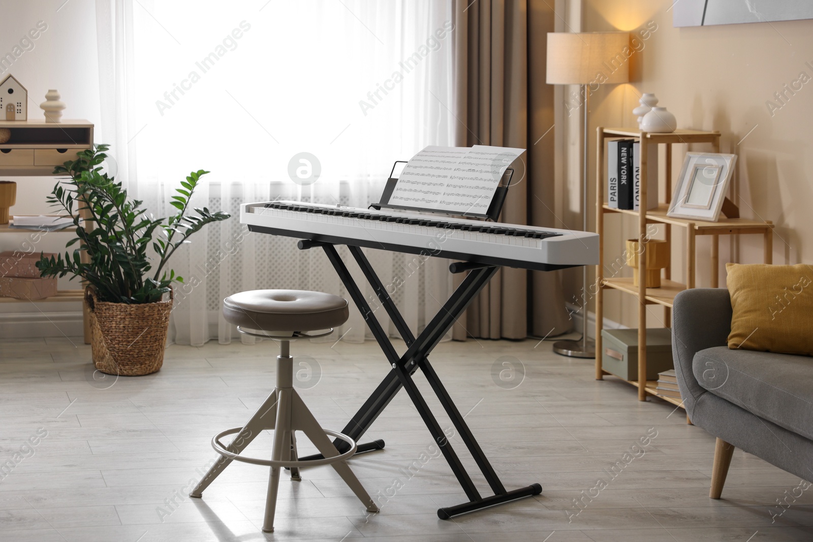 Photo of Synthesizer with music sheets and stool indoors