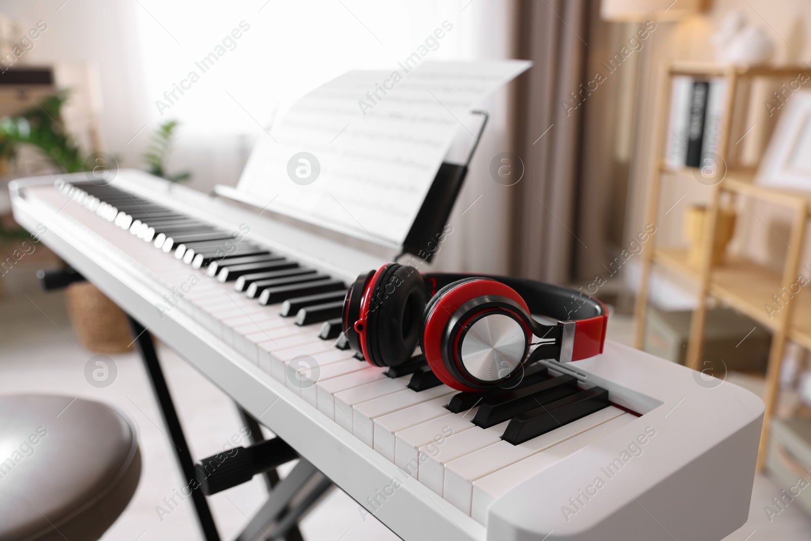 Photo of Synthesizer with music sheets and headphones indoors, closeup