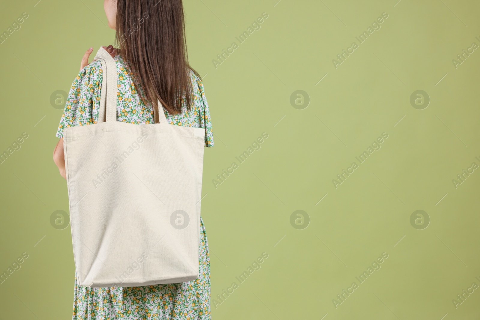 Photo of Woman with blank shopper bag on color background, back view. Mockup for design