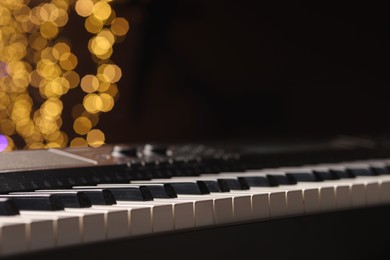 Photo of Piano against blurred lights, closeup with space for text. Bokeh effect