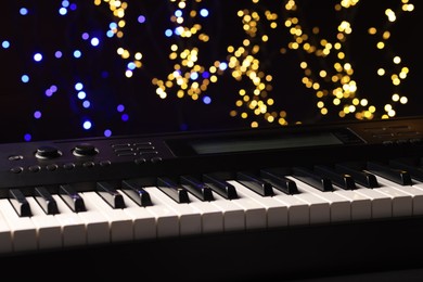 Photo of Piano against blurred lights, closeup. Bokeh effect