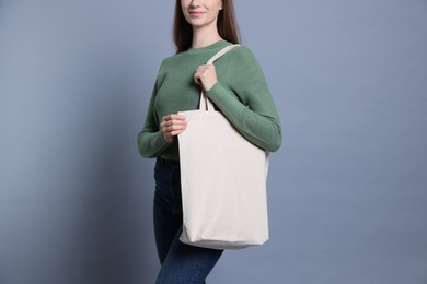 Photo of Woman with blank shopper bag on grey background, closeup. Mockup for design