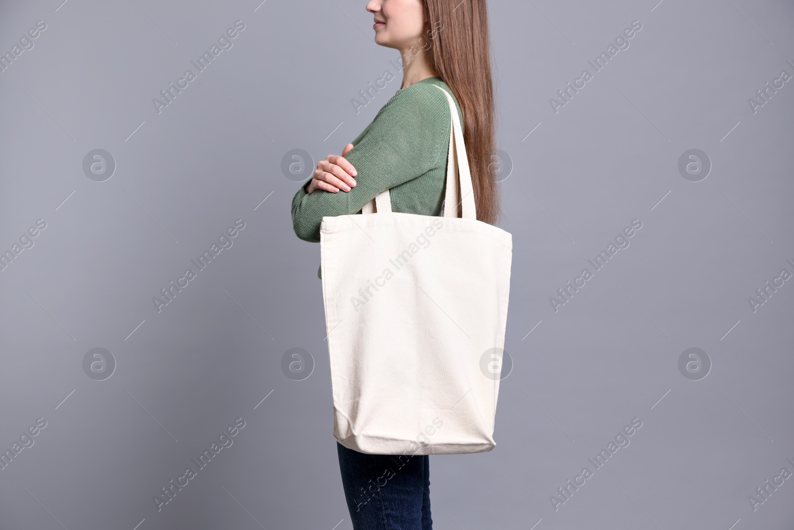 Photo of Woman with blank shopper bag on grey background, closeup. Mockup for design