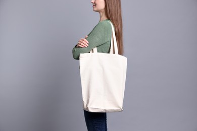 Photo of Woman with blank shopper bag on grey background, closeup. Mockup for design