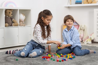 Children playing with colorful cubes on floor indoors