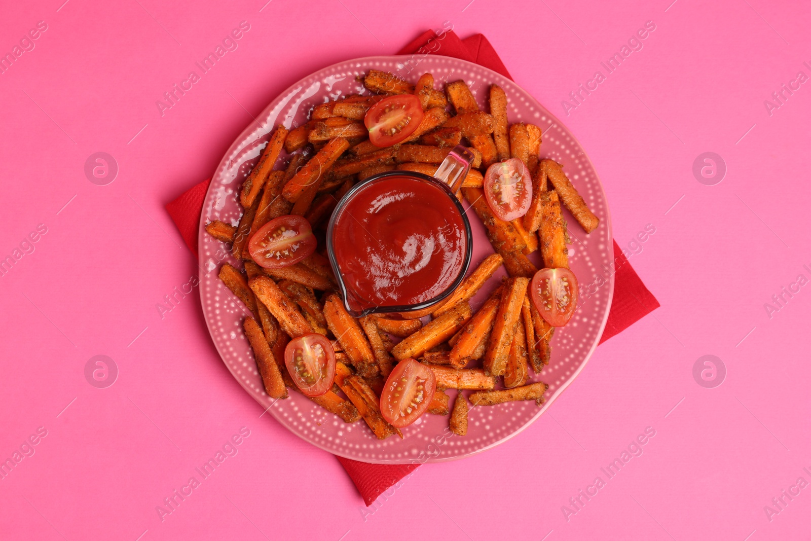 Photo of Tasty ketchup, tomatoes and fried carrots on pink background, top view